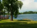 Malownicze jezioro Szczutowskie z altanami na brzegu, otoczone zielenią.