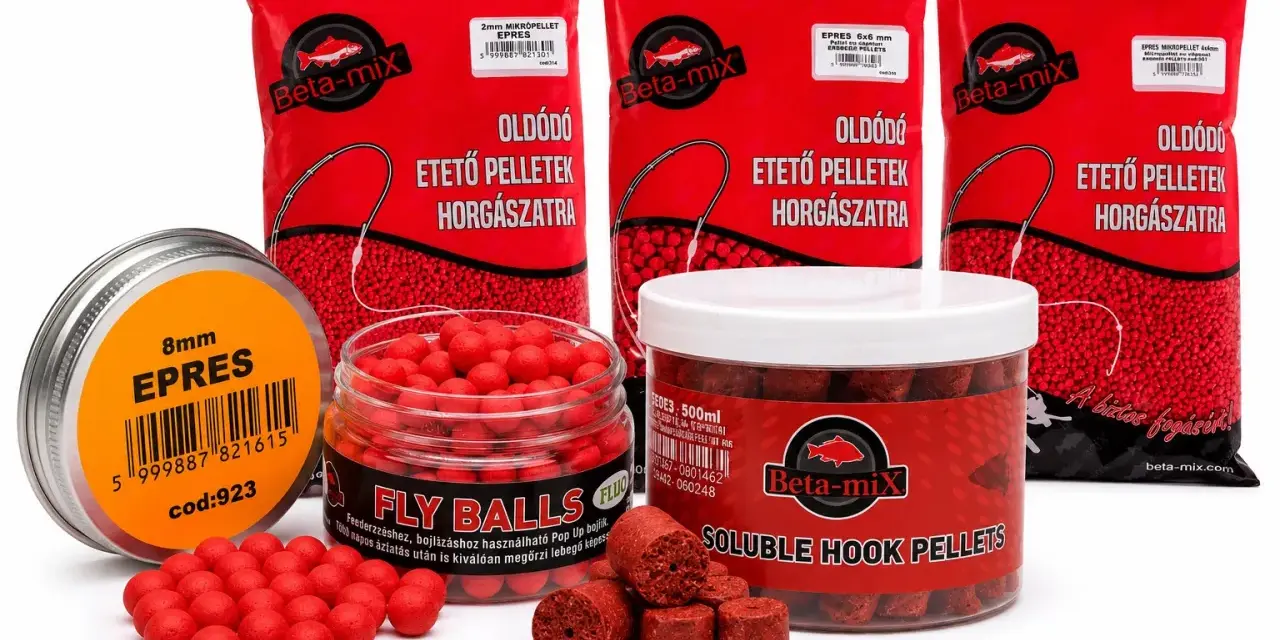 Domowe przynęty na ryby: czerwone kulki i pellety w opakowaniach Beta-mix, gotowe do akcji.