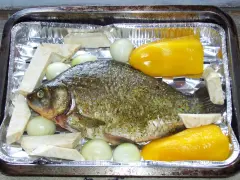 Karp przyprawiony, gotowy do pieczenia z cebulą, selerem i papryką. Idealny przepis, jak przyrządzić karasia.