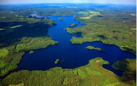 Malownicze miastko jezioro otoczone lasami, z licznymi wyspami i zatoczkami.