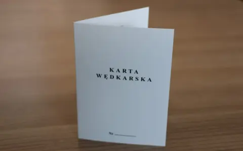 Oto jak wygląda karta wędkarska: biała, złożona kartka z napisem "KARTA WĘDKARSKA" i miejscem na numer.