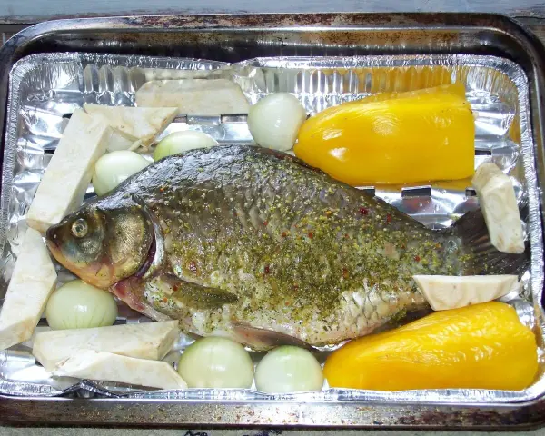 Karp przyprawiony, gotowy do pieczenia z cebulą, selerem i papryką. Idealny przepis, jak przyrządzić karasia.