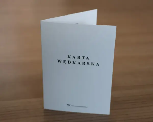 Oto jak wygląda karta wędkarska: biała, złożona kartka z napisem "KARTA WĘDKARSKA" i miejscem na numer.